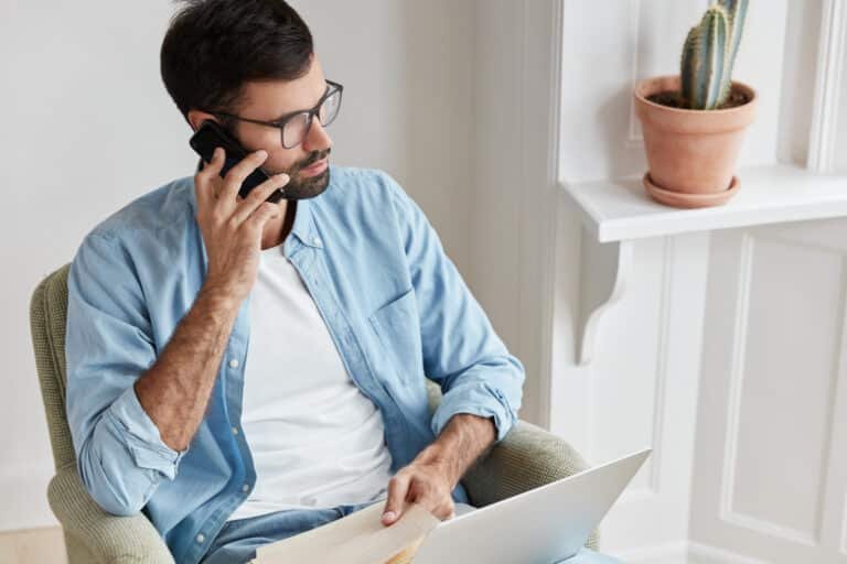 Homme en train de travailler sur un ordinateur portable et de parler au téléphone.