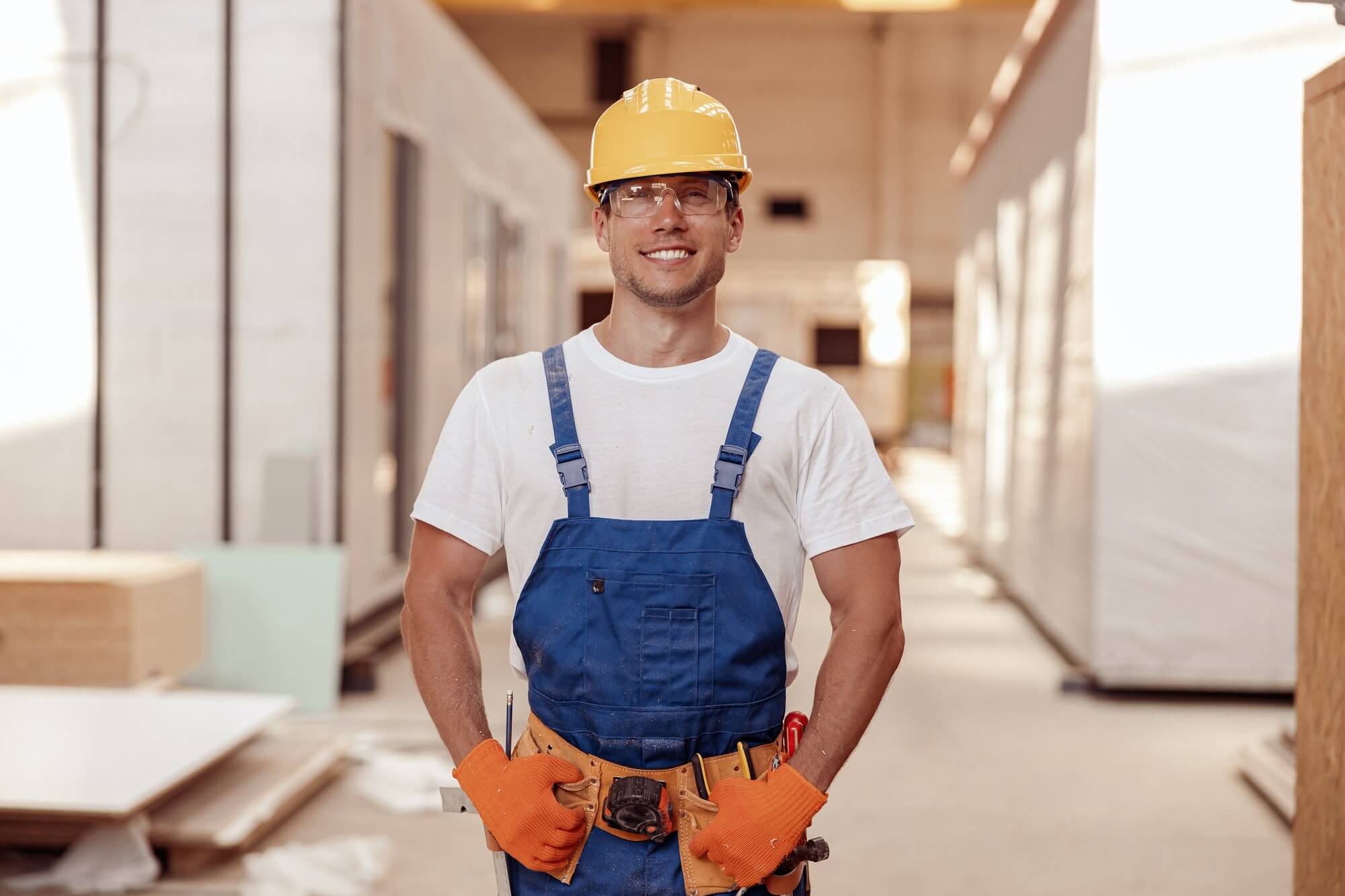 Ouvrier souriant en équipement de sécurité sur un chantier.